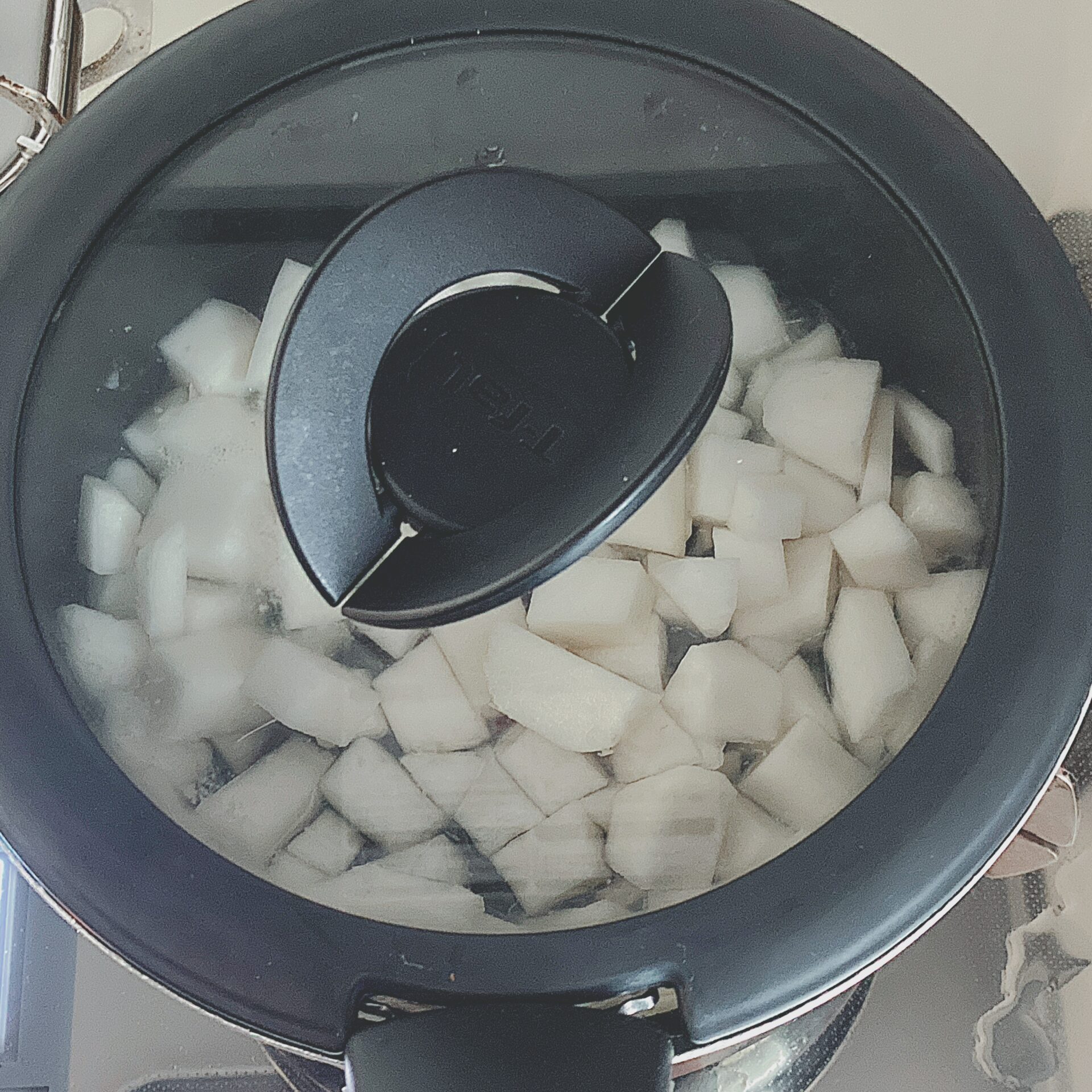 蓋をした鍋でかぶを煮ている写真